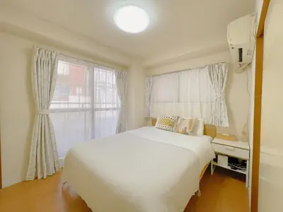 a bedroom with a white bed and a window at Sakura Stay \u62bc\u4e0a in Tokyo