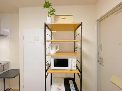 a kitchen with a microwave on a shelf at Sakura Stay \u62bc\u4e0a in Tokyo