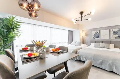 a room with two beds and a dining table with fruit on it at tai\u4e21\u56fd4\u4e01\u76eeGLV\u516c\u9928401 in Tokyo