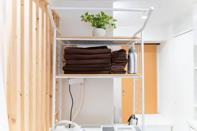 a shelf with towels and a plant on it at tai\u4e21\u56fd4\u4e01\u76eeGLV\u516c\u9928701 in Tokyo
