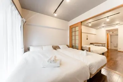 a bedroom with two beds with towels on them at shibuya e adress in Tokyo