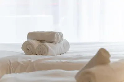 a pile of towels sitting on top of a bed at shibuya e adress in Tokyo