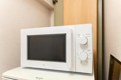 a microwave oven sitting on top of a refrigerator at shibuya e adress in Tokyo