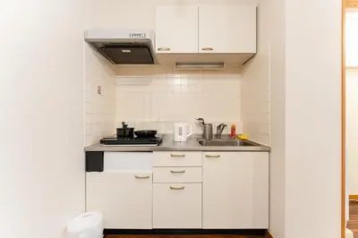 a kitchen with white cabinets and a sink at shibuya e adress in Tokyo