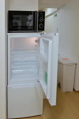 an open refrigerator with a microwave on top of it at Karawaru Stay \u5e73\u4e95 A in Tokyo