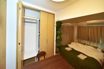 a bedroom with a large bed and a table at Karawaru Stay \u5e73\u4e95 A in Tokyo
