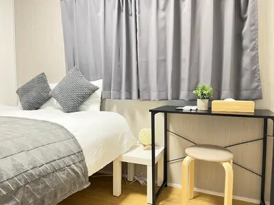 a bedroom with a bed and a table and a chair at Ikebukuro Area 2F3 KamiikeApartment in Tokyo