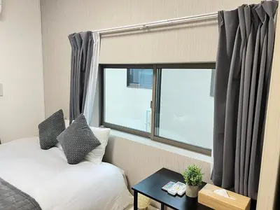 a bedroom with a bed and a large window at Ikebukuro Area 2F3 KamiikeApartment in Tokyo