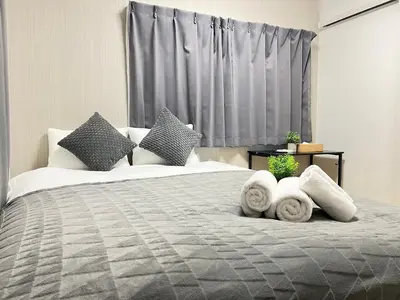 a bedroom with a large bed with towels on it at Ikebukuro Area 2F3 KamiikeApartment in Tokyo