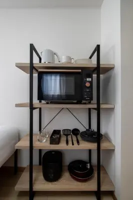 a microwave on a shelf in a room at CraftFlat Komagome 605, a compact studio at excellent location in Tokyo