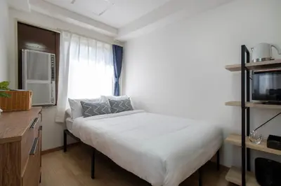 a small bedroom with a bed and a window at CraftFlat Komagome 605, a compact studio at excellent location in Tokyo