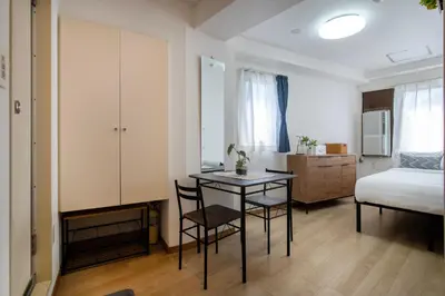 a bedroom with a bed and a table and chairs at CraftFlat Komagome 605, a compact studio at excellent location in Tokyo