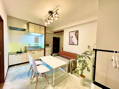 a kitchen and a living room with a table and chairs at \u9daf\u8c37 3\u5bdd\u5ba44\u30d9\u30c3\u30c9 \u6700\u4e0a\u968e \u9daf\u8c37\u99c5\u5f92\u6b692\u5206 \u6d45\u8349\u4e0a\u91ce\u79cb\u8449\u539f\u30a8\u30ea\u30a2 in Tokyo