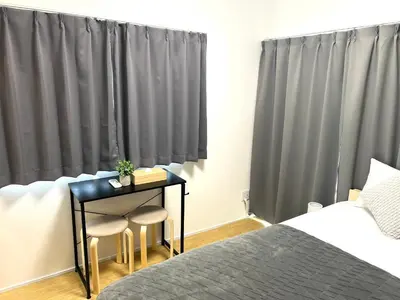 a bedroom with a bed and a table with two stools at Ikebukuro Area 2 Units 1112 KamiikeApartment in Tokyo