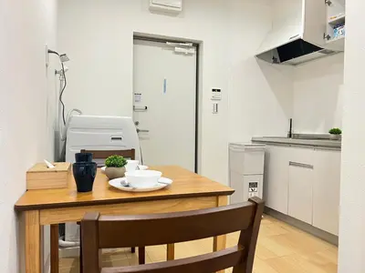 a small kitchen with a wooden table and chairs at Ikebukuro Area 2 Units 1112 KamiikeApartment in Tokyo