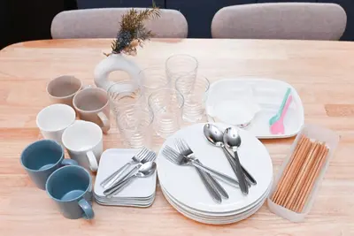 a wooden table with plates and utensils on it at Modern & Spacious Family House - 15 mins to Haneda Airport in Tokyo