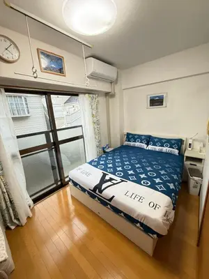 a small bedroom with a bed and a clock on the wall at \u6771\u4eac\u6fd5\u6696\u7684\u5bb6-Tokyo Warm Home -28 Square King Room205 in Tokyo