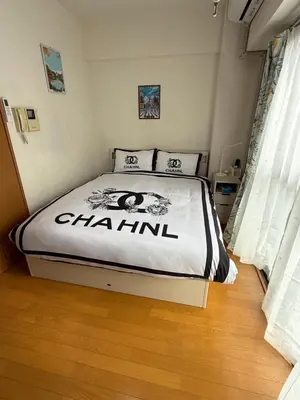 a bedroom with a bed with a chanel sign on it at \u6771\u4eac\u6fd5\u6696\u7684\u5bb6-Tokyo Warm Home -28 Square King Room205 in Tokyo