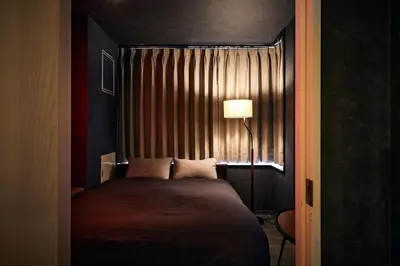 a bedroom with a bed with a lamp and a window at Hotel-Mercurius-Azabujuban-RB in Tokyo