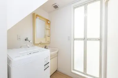 a bathroom with a sink and a washing machine at Direct bus from Haneda 3BR House Near Station in Tokyo