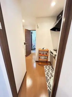 a hallway leading to a kitchen with white walls at \u8c4a\u5cf6\u5927\u585a\u3055\u304f\u3089\u6c11\u6cca in Tokyo