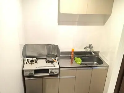 a kitchen with a stove and a sink at \u8c4a\u5cf6\u5927\u585a\u3055\u304f\u3089\u6c11\u6cca in Tokyo