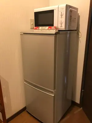 a microwave sitting on top of a refrigerator at \u8c4a\u5cf6\u5927\u585a\u3055\u304f\u3089\u6c11\u6cca in Tokyo
