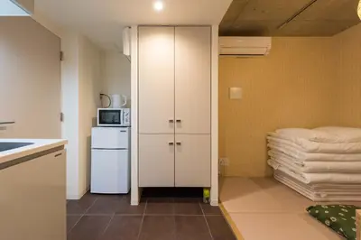 a small kitchen with a refrigerator and a microwave at Fare Metallo Tokyo Nakano 11-room Hotel in Tokyo
