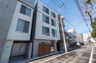 an empty street in front of a white building at Fare Metallo Tokyo Nakano 11-room Hotel in Tokyo
