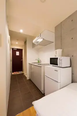 a small kitchen with a sink and a microwave at Fare Metallo Tokyo Nakano 11-room Hotel in Tokyo