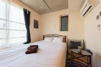 a bedroom with a bed with a towel on it at Fare Metallo Tokyo Nakano 11-room Hotel in Tokyo