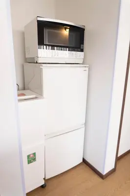 a microwave sitting on top of a refrigerator at Skytree-House\u4eac\u5cf6 in Tokyo