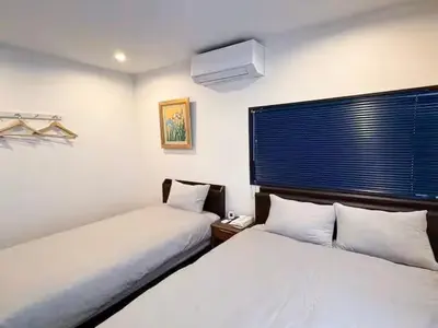 a bedroom with two beds and a window with a phone at Skytree-House\u4eac\u5cf6 in Tokyo