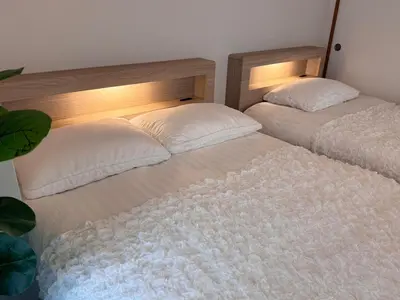 two beds sitting next to each other in a room at Moto Sakura for families 3 luxury beds 2bedroom apartment in a quiet and convenient location in Tokyo