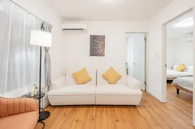 a white living room with a couch and a bed at Mori house \u6839\u5cb8 401 in Tokyo