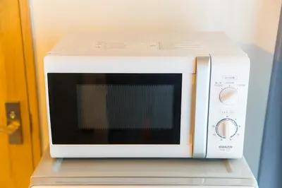 a white microwave oven sitting on top of a shelf at Azur Shibuya -Apartment House- in Tokyo