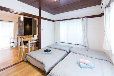 a bedroom with two beds and a table in it at Azur Shibuya -Apartment House- in Tokyo