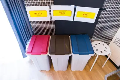 a group of four trash cans sitting next to a wall at Azur Shibuya -Apartment House- in Tokyo
