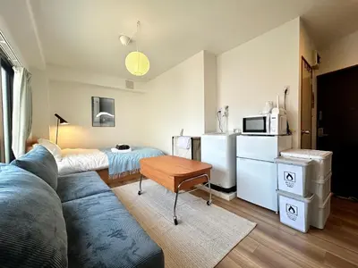 a living room with a couch and a table and a kitchen at \u30c8\u30e9\u30a4\u30a2\u30f3\u30b0\u30eb\u82e5\u5bae201 trianglewakamiya in Tokyo