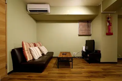 a living room with a black leather couch and a table at Best Value 2BR that Sleep 6, Quiet neighborhood, Close to Metro in Tokyo