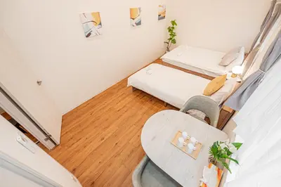 a small room with two beds and a table at Mori house \u6839\u5cb8 402 in Tokyo