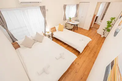 a living room with two beds and a table at Mori house \u6839\u5cb8 402 in Tokyo