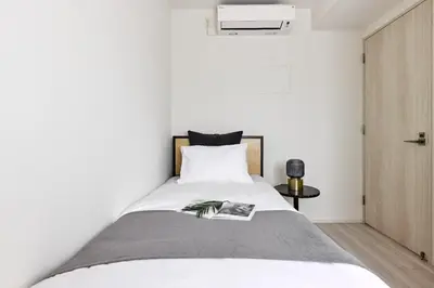 a bedroom with a bed with a book on it at \u30a2\u30fc\u30d0\u30cd\u30c3\u30af\u30b9\u9326\u7cf8\u753aNorth in Tokyo