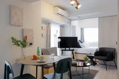a living room with a table and a bedroom at \u30a2\u30fc\u30d0\u30cd\u30c3\u30af\u30b9\u9326\u7cf8\u753aNorth in Tokyo