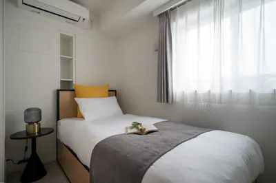 a bedroom with a bed with a book on it at \u30a2\u30fc\u30d0\u30cd\u30c3\u30af\u30b9\u9326\u7cf8\u753aNorth in Tokyo