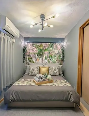 a bedroom with a large bed with a flower painting on the wall at Sakura Fan 2F in Tokyo