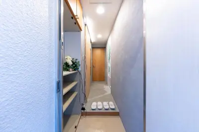 a hallway with a door leading into a room with white walls at Sakura Fan 2F in Tokyo