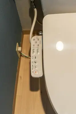 a remote control attached to the side of a toilet at Sakura Fan 2F in Tokyo