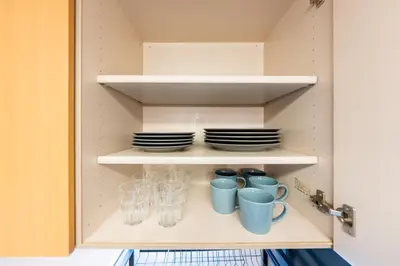 a cupboard with plates and cups and glasses at Sakura Fan 2F in Tokyo