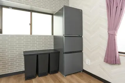 a refrigerator and a stool in a room with a brick wall at Comfort Stay \u4e2d\u91ce in Tokyo
